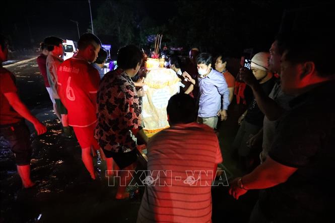 Trong ảnh: Di chuyển linh cữu lên bè để đưa lên vùng khô ráo cử hành tang lễ. Ảnh: Thành Đạt - TTXVN