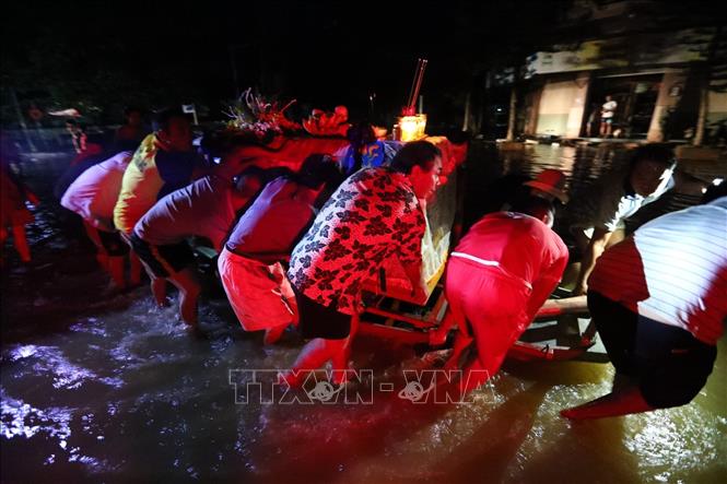 Trong ảnh: Tranh thủ nước rút, ngay trong đêm gia đình có người mất di chuyển ngay linh cữu đi an táng. Ảnh: Thành Đạt - TTXVN
