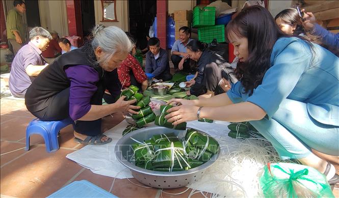 Trong ảnh: Người dân La Phù cùng nhau gói bánh chưng. Ảnh: Nguyễn Cúc - TTXVN