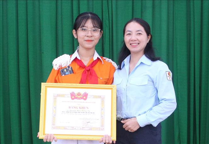 Trong ảnh: Chủ tịch Hội đồng đội tỉnh Vĩnh Long Nguyễn Thụy Yến Phương trao giải thưởng Kim Đồng của Trung ương Đoàn cho em Nguyễn Ngọc Tường Vy. Ảnh: Lê Thúy Hằng – TTXVN