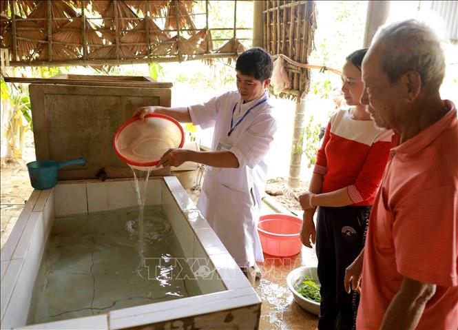 Trong ảnh: Nhân viên Trung tâm Y tế dự phòng huyện Lệ Thủy tiến hành khử khuẩn nước sinh hoạt bằng dung dịch Cloramin B cho hộ Nguyễn Ngọc Thái ở thôn Mai Thúy, xã Mai Thủy. Ảnh: Vũ Sinh - TTXVN