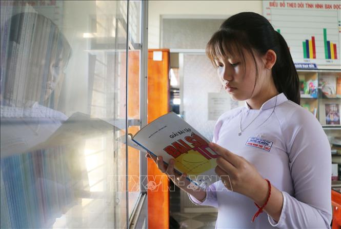 Trong ảnh: Em Đặng Minh Thư luôn tranh thủ trời gian rảnh lên thư viện trường để đọc thêm tài liệu. Ảnh: Công Mạo - TTXVN