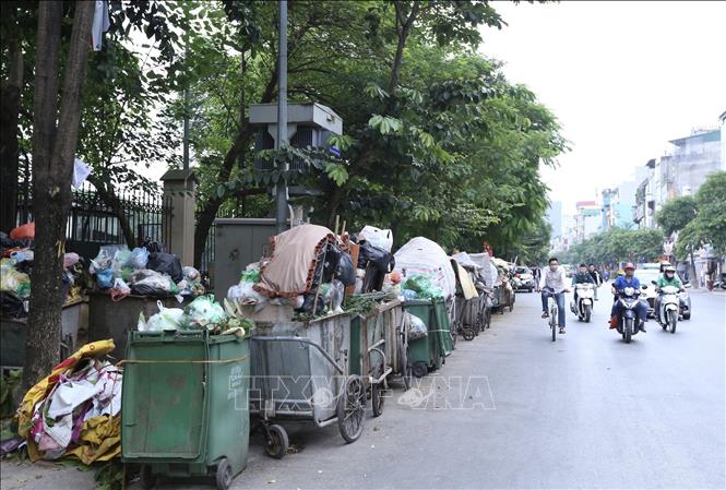 Trong ảnh: Xe chở rác xếp đầy vỉa hè và cả dưới lòng đường Bạch Mai, quận Hai Bà Trưng (ảnh chụp lúc 13h ngày 25/10/2020). Ảnh: Hoàng Hiếu - TTXVN
