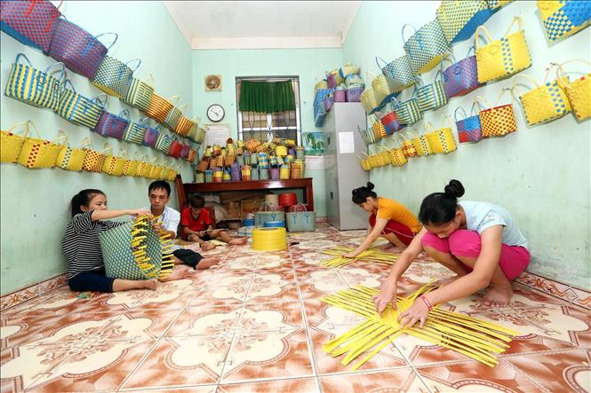 Trong ảnh: Giáo viên dạy nghề Nguyễn Văn Ngọ, 30 năm công tác, là con liệt sỹ, bị khuyết tật, trước đây được điều trị, học tập tại Trung tâm, được Trung tâm cho đi đào tạo nghề và tiếp nhận làm giáo viên đang dạy nghề đan cho học sinh khuyết tật. Ảnh: Anh Tuấn – TTXVN