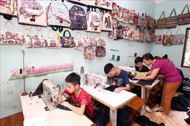 Trong ảnh: Giáo viên dạy nghề Phan Thị Yến, 37 tuổi, 10 năm công tác đang dạy nghề may cho học sinh khuyết tật (khiếm thính). Ảnh: Anh Tuấn – TTXVN