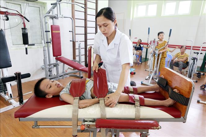 Trong ảnh: Kỹ thuật viên Kiều Thanh Hoa 29 tuổi, 8 năm công tác đang điều trị PHCN cho trẻ em khuyết tật. Ảnh: Anh Tuấn – TTXVN