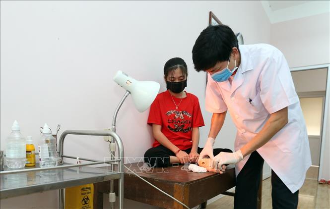 Trong ảnh: Đảng viên, Phó giám đốc, bác sỹ Nguyễn Ngọc Tân 52 tuổi, 20 năm công tác (Bằng khen của Bộ LĐTBXH năm 2009) đang khám, điều trị cho trẻ em khuyết tật trong giai đoạn dịch COVID-19. Ảnh: Anh Tuấn – TTXVN