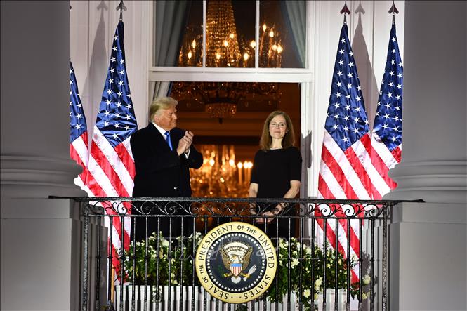 Trong ảnh: Tổng thống Mỹ Donald Trump (trái) chúc mừng bà Amy Coney Barrett (phải) sau lễ tuyên thệ nhậm chức Thẩm phán Tòa án Tối cao tại Washington, DC ngày 26/10/2020. Ảnh: AFP/TTXVN