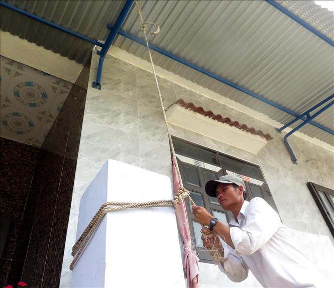 Trong ảnh: Người dân chủ động chằng chống, gia cố nhà cửa để tránh thiệt hại về tài sản. Ảnh: Lê Ngọc Phước- TTXVN
