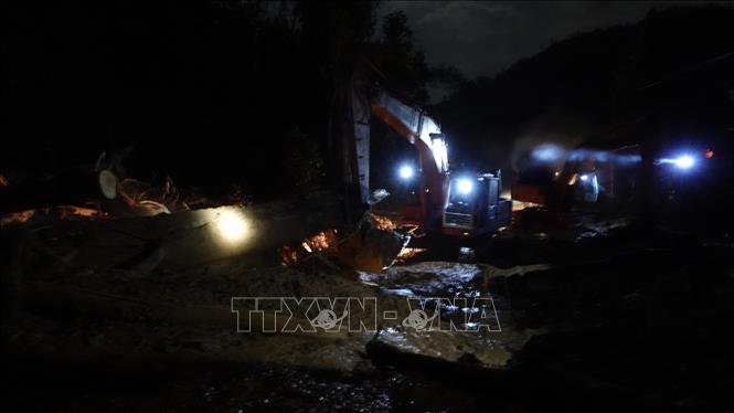 Trong ảnh: Lực lượng chức năng khẩn trương thông đường vào khu vực sạt lở Trà Leng. Ảnh: Vỹ Thi-TTXVN