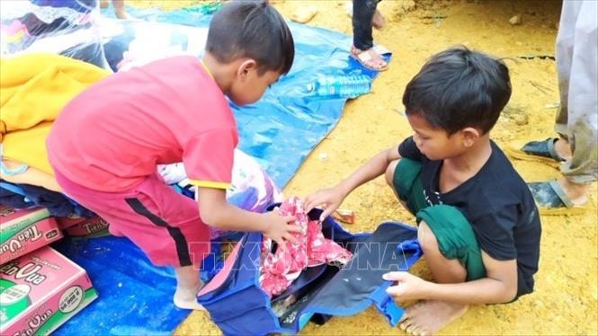 Trong ảnh: Trẻ em tại khu vực bị sạt lở Trà Leng nhận đồ cứu trợ. Ảnh: Trần Lê Lâm-TTXVN