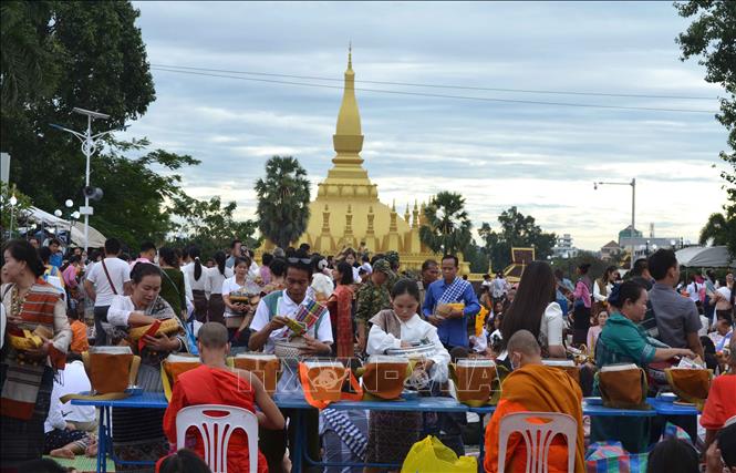 Trong ảnh: Người dân dâng lễ cho các nhà sư tại chùa Thạt Luổng. Ảnh: Thu Phương - Pv TTXVN tại Lào
