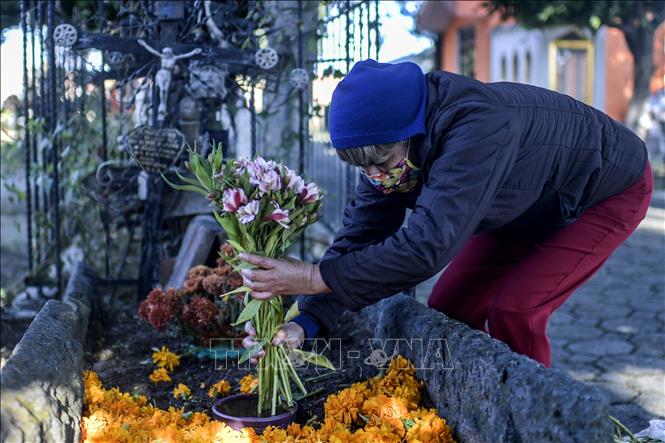 Trong ảnh: Người dân trang trí mộ của người thân trong lễ hội 