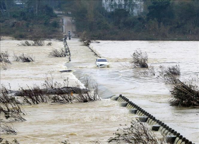 Trong ảnh: Người dân điều khiển phương tiện vượt dòng nước chảy xiết. Ảnh: Lê Ngọc Phước- TTXVN
