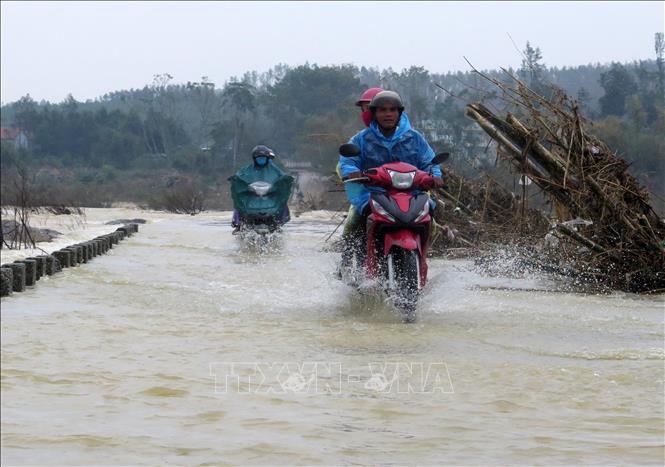 Trong ảnh: Người dân điều khiển phương tiện vượt dòng nước chảy xiết. Ảnh: Lê Ngọc Phước- TTXVN

