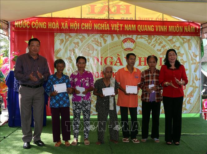 Trong ảnh: Bà Lê Thị Vệ (áo đỏ), Chủ tịch Ủy ban Mặt trận Tổ quốc Việt Nam tỉnh Kiên Giang tặng quà cho bà con dân tộc Khmer nghèo trên địa bàn dân cư ấp Vĩnh Đằng.
Ảnh: Lê Sen - TTXVN