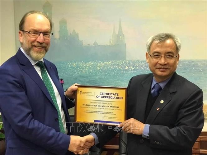 Trong ảnh: Chủ tịch Phòng Thương mại và Công nghiệp Ukraine (UCCI) Gennadiy Chyzhykov (bên trái) trao tặng bằng khen cho Đại sứ Việt Nam tại Ukraine Nguyễn Anh Tuấn. Ảnh: TTXVN phát
 