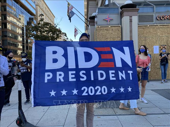 Trong ảnh: Người dân Mỹ cầm những tấm biển ủng hộ ứng cử viên Joe Biden để ăn mừng chiến thắng. Ảnh: Đặng Huyền - PvTTXVN tại Mỹ
