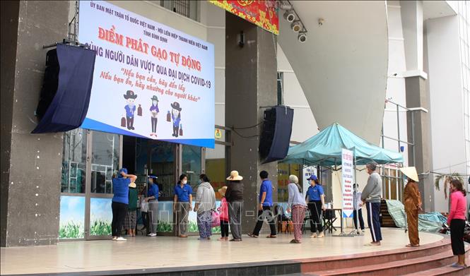 Trong ảnh: Người dân thành phố Quy Nhơn xếp hàng nhận gạo tại Nhà Văn hóa Lao động tỉnh Bình Định do Ban Cứu trợ - Ủy ban Mặt trận Tổ quốc Việt Nam tỉnh tổ chức nhằm hỗ trợ người dân trong công tác phòng chống dịch COVID-19. Ảnh: Nguyên Linh - TTXVN