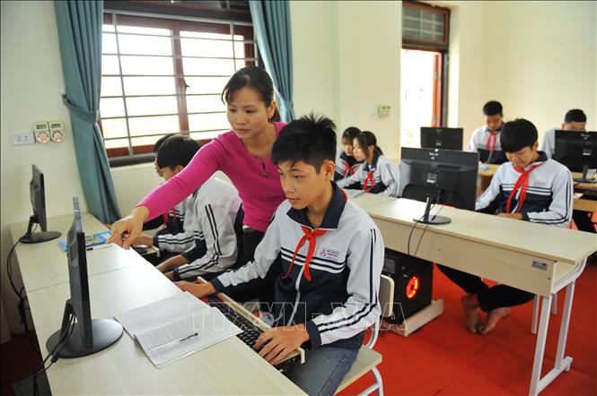 Cô và trò trường THCS Ninh Giang trong giờ học môn Tin học.Ảnh: Minh Đức - TTXVN