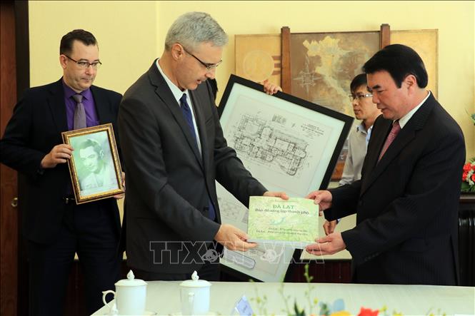 Photo: French Ambassador to Vietnam Nicolas Warnery presents a book on Da Lat city to the local authorities. VNA Photo