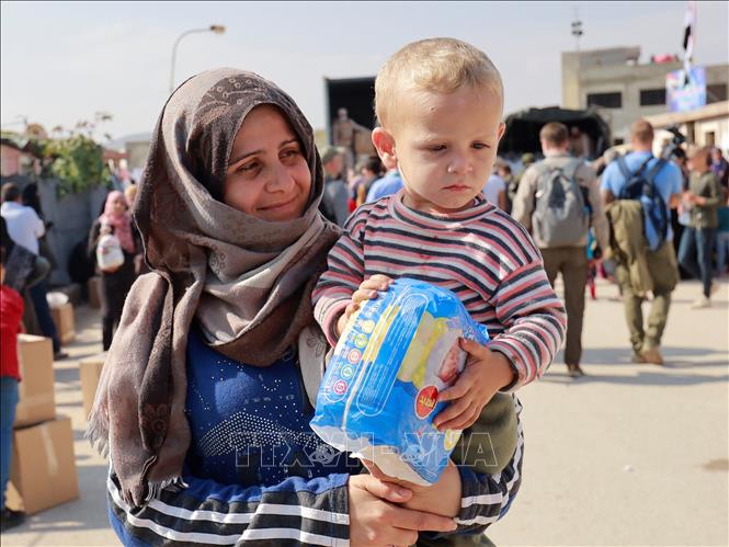 Trong ảnh: Niềm vui của người dân tị nạn khi được nhận đồ dùng thiết yếu từ đoàn cứu trợ. Ảnh: Trần Hiếu - Pv TTXVN