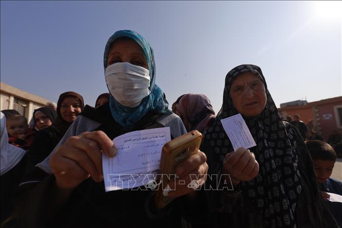 Trong ảnh: Người dân tị nạn mang trên tay những phiếu lĩnh nhu yếu phẩm từ đoàn cứu trợ nhân đạo. Ảnh: Trần Hiếu - Pv TTXVN