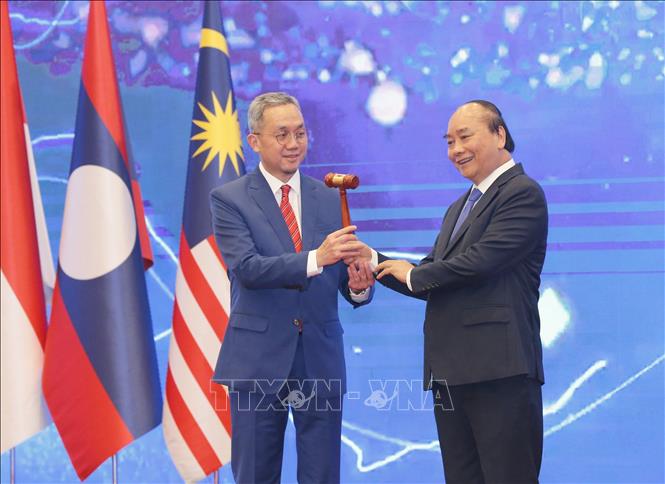Photo: Vietnamese Prime Minister Nguyen Xuan Phuc (R) hands the chairmanship hammer to Brunei Ambassador to Vietnam Pengiran Haji Sahari bin Pengiran Haji Salleh. VNA Photo