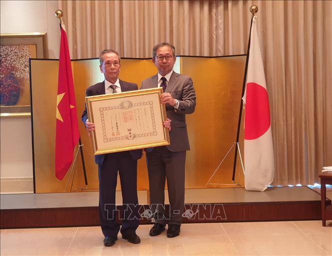 Photo: Japanese Ambassador to Vietnam Yamada Takio (R) presents the award to Associate Professor, Dr. Tran Son (L). VNA Photo: Phương Anh