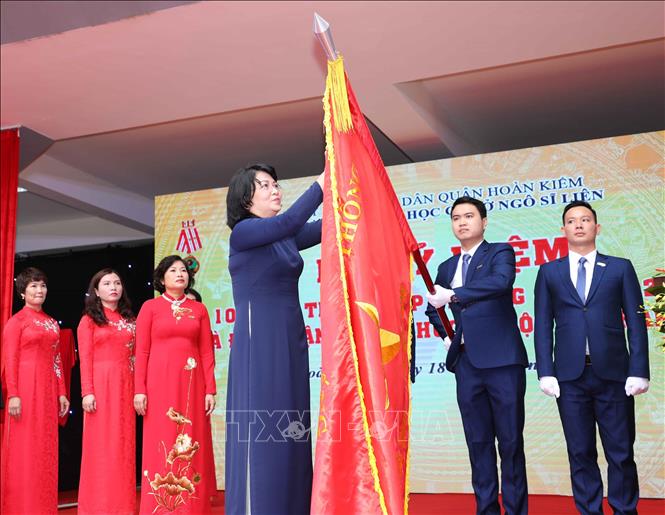 Trong ảnh: Phó Chủ tịch nước Đặng Thị Ngọc Thịnh gắn Huân chương Độc lập hạng Nhì lên lá cờ truyền thống của nhà trường. Ảnh: Thanh Tùng - TTXVN