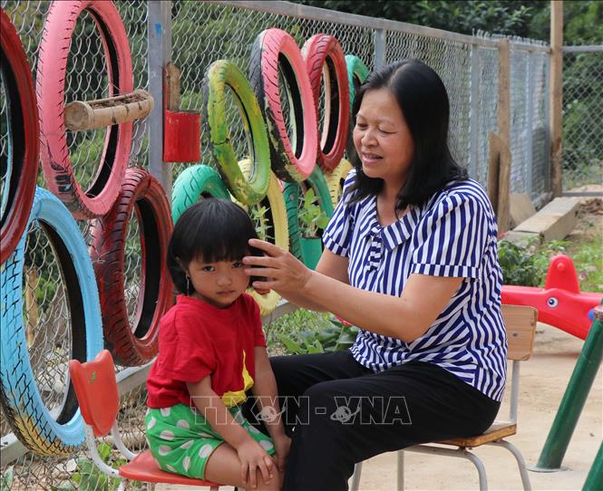 Cô giáo Lê Thị Loan chăm sóc, chải tóc cho học sinh của mình.Ảnh: Xuân Tiến - TTXVN.