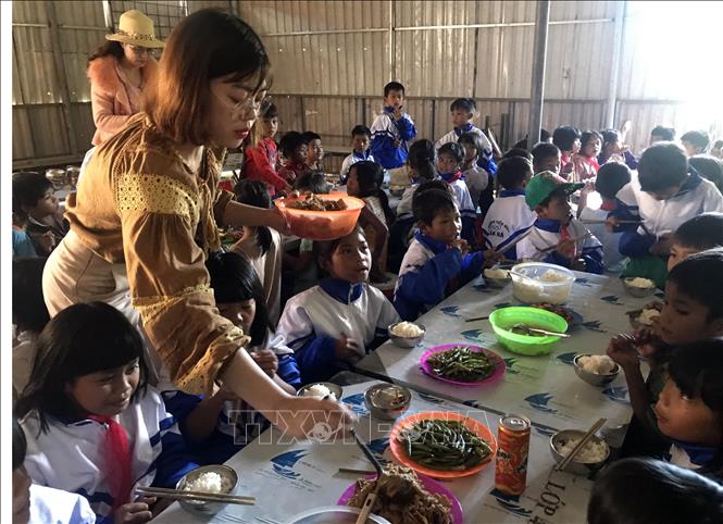 Trong ảnh: Các cô giáo tại trường Tiểu học xã Đăk Hà chia phần ăn cho các em học sinh. Ảnh: Khoa Chương - TTXVN