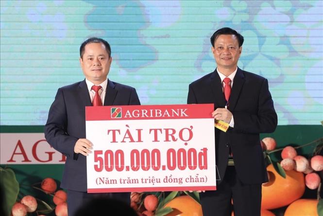 Trong ảnh: Đại diện ngân hàng Agribank trao tượng trưng tài trợ 500 triệu đồng cho Ban tổ chức Hội chợ. Ảnh: Minh Quyết- TTXVN