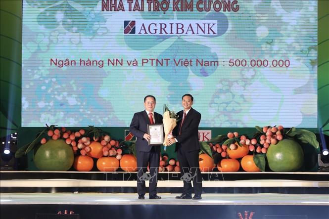 Trong ảnh: Đại diện UBND huyện Lục Ngạn trao kỷ niệm chương cho đại diện nhà tại trợ kim cương, ngân hàng Agribank. Ảnh: Minh Quyết - TTXVN