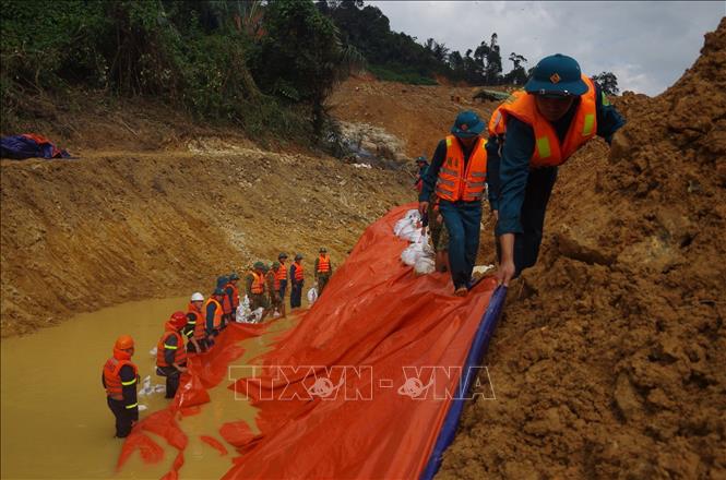 Trong ảnh: Lực lượng cứu hộ nỗ lực hoàn thành việc nắn sông để sớm tìm kiếm các nạn nhân dưới lòng sông Rào Trăng. Ảnh: TTXVN phát
