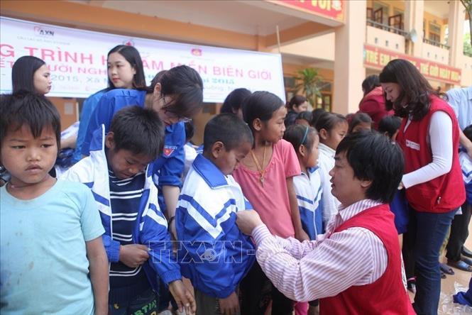 Trong ảnh: Cán bộ Hội Chữ thập đỏ Nghệ An tặng áo ấm đồng phục cho học sinh Trường Tiểu học 3 Môn Sơn, huyện Con Cuông. Ảnh: Thanh Tùng - TTXVN