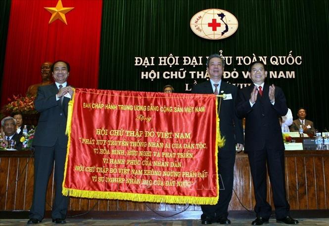 Trong ảnh: Chủ tịch nước Nguyễn Minh Triết trao tặng bức trướng của Ban chấp hành Trung ương Đảng cho Hội Chữ thập đỏ Việt Nam tại Đại hội đại biểu toàn quốc Hội Chữ thập đỏ Việt Nam lần thứ VIII (29/6/2007). Ảnh: Nguyễn Khang -TTXVN