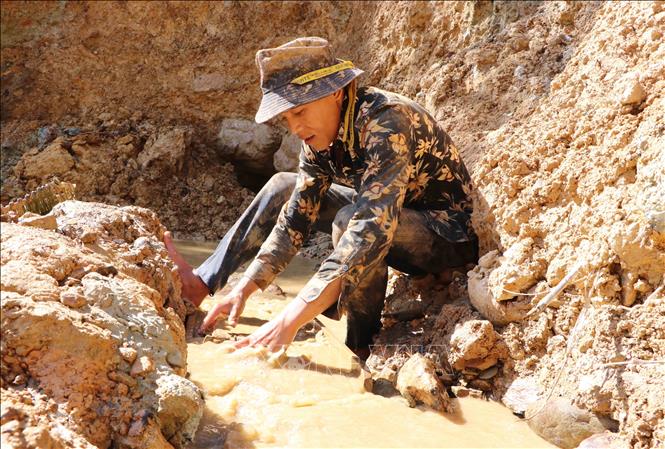 Phu vàng Phạm Văn Đức đãi vàng ngay gần hầm khai thác. Ảnh: Hoàng Thùy Oanh-TTXVN.