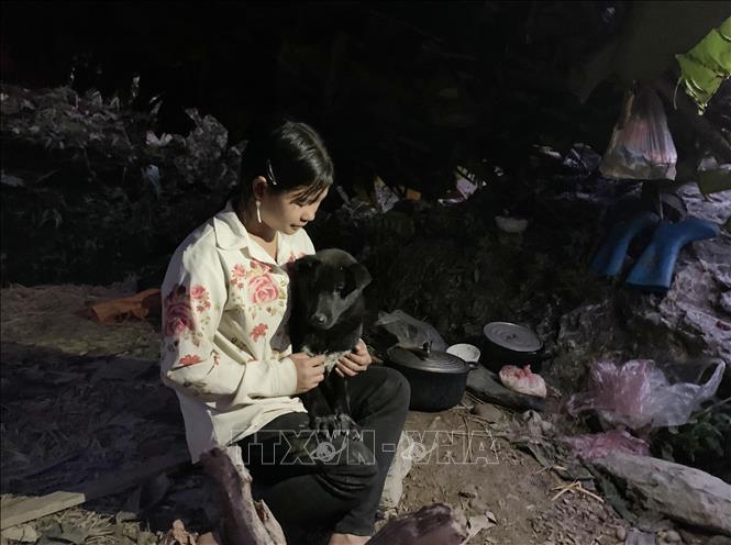 Buổi tối trong rừng sâu, cô bé Lý Xa Mẩy, 15 tuổi, ở bản Nậm Tảng 2, xã Hua Bum, huyện Nậm Nhùn chỉ biết tìm niềm vui bên chú chó mang theo cùng. Ảnh: Hoàng Thùy Oanh-TTXVN