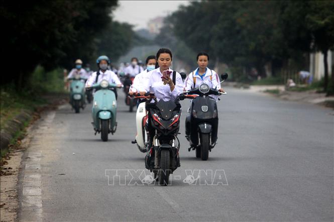 Trong ảnh: Học sinh đi xe máy điện sử dụng điện thoại trên đường 10B đoạn qua thị trấn Vũ Thư, tỉnh Thái Bình. Ảnh: Thế Duyệt - TTXVN