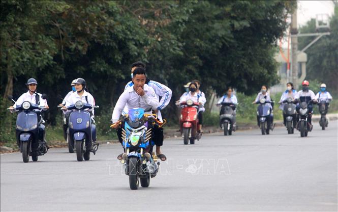 Trong ảnh: Học sinh đi xe máy điện không đội mũ bảo hiểm, dàn hàng ngang trên đường 10B đoạn qua thị trấn Vũ Thư, tỉnh Thái Bình. Ảnh: Thế Duyệt - TTXVN
