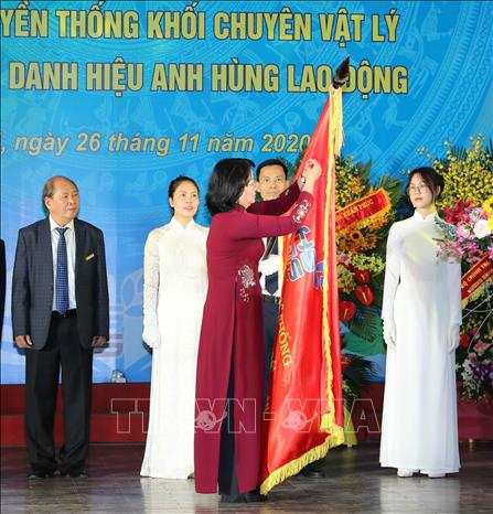 Trong ảnh: Phó Chủ tịch nước Đặng Thị Ngọc Thịnh gắn Danh hiệu Anh hùng Lao động lên lá cờ truyền thống của trường THPT Chuyên Khoa học tự nhiên. Ảnh: Thanh Tùng - TTXVN 