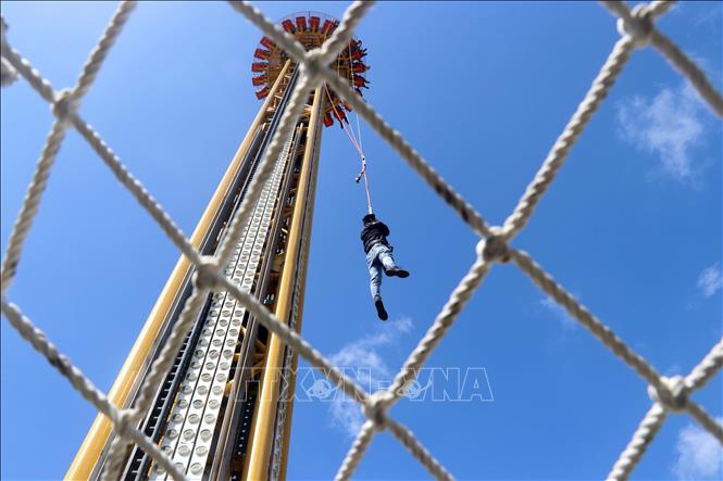Trong ảnh: Diễn tập giải cứu đưa người bị kẹt trên trò chơi tháp rơi xuống đất an toàn bằng cách đu dây. Ảnh: Trần Lê Lâm - TTXVN 