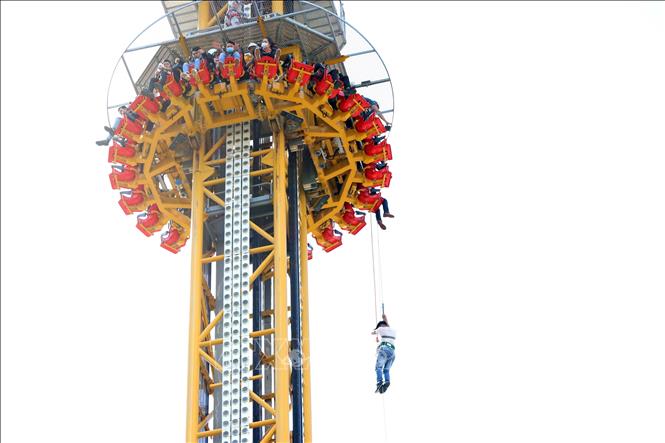 Trong ảnh: Diễn tập giải cứu đưa người bị kẹt trên trò chơi tháp rơi xuống đất an toàn bằng cách đu dây. Ảnh: Trần Lê Lâm - TTXVN 