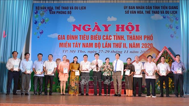 Bà Châu Thị Mỹ Phương, Ủy viên dự khuyết Trung ương Đảng, Trưởng Ban Tuyên giáo Tỉnh ủy Tiền Giang trao quà lưu niệm cho các gia đình tiêu biểu. Ảnh: Hữu Chí - TTXVN