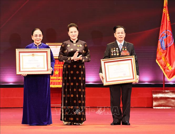 Trong ảnh: Chủ tịch Quốc hội Nguyễn Thị Kim Ngân trao danh hiệu Anh hùng Lao động cho ông Lê Văn Kiểm và bà Trần thị Cẩm Nhung. Ảnh: Trọng Đức - TTXVN