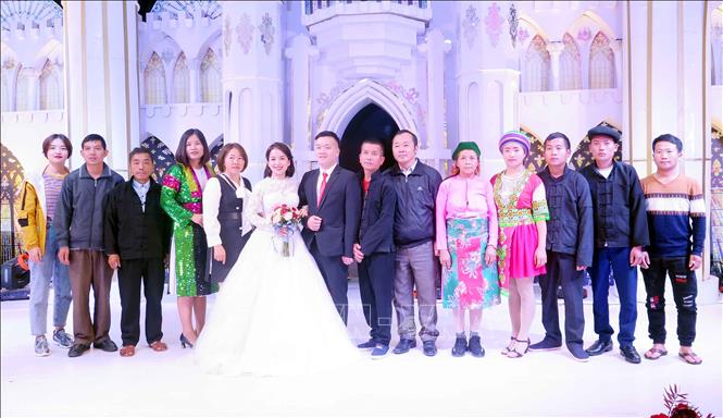 Cô dâu chú rể chụp ảnh lưu niệm cùng gia đình trong Lễ cưới tập thể. Ảnh: Thu Hằng-TTXVN