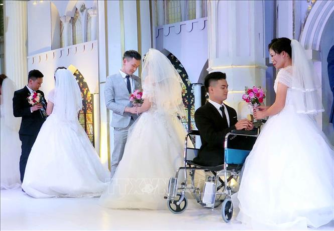 Các cặp đôi thực hiện nghi lễ trao nhẫn cưới tại Lễ cưới tập thể. Ảnh: Thu Hằng-TTXVN