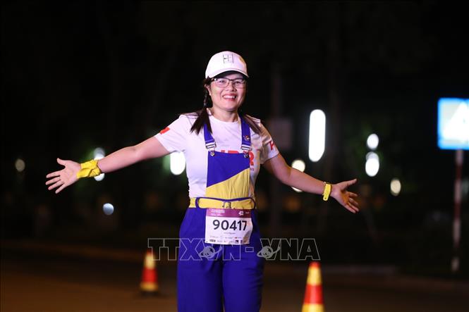 Trong ảnh: Các vận động viên thích thú khi trải nghiệm giải chạy trong đêm đầu tiên tại Hà Nội. Ảnh: Thành Đạt - TTXVN