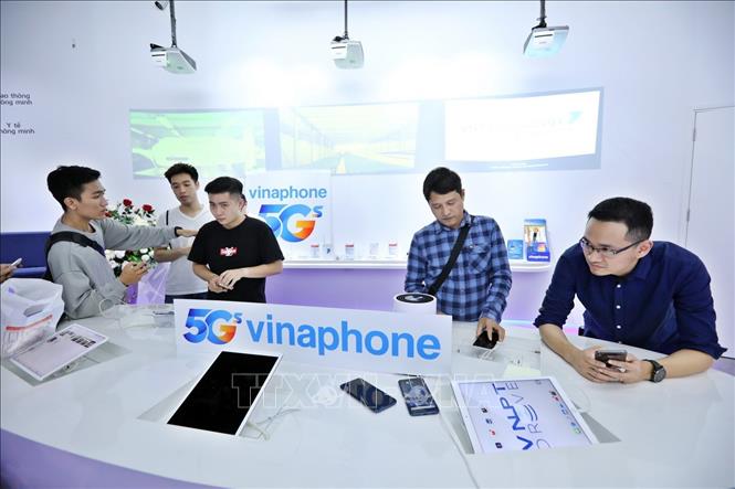 Trong ảnh: Những khách hàng đầu tiên được chính thức trải nghiệm VinaPhone 5G trên các thiết bị điện thoại 5G với tốc độ truy cập Internet di động lên đến hơn 1 Gbps, gấp hơn 10 lần tốc độ 4G hiện nay. Ảnh: Minh Quyết - TTXVN